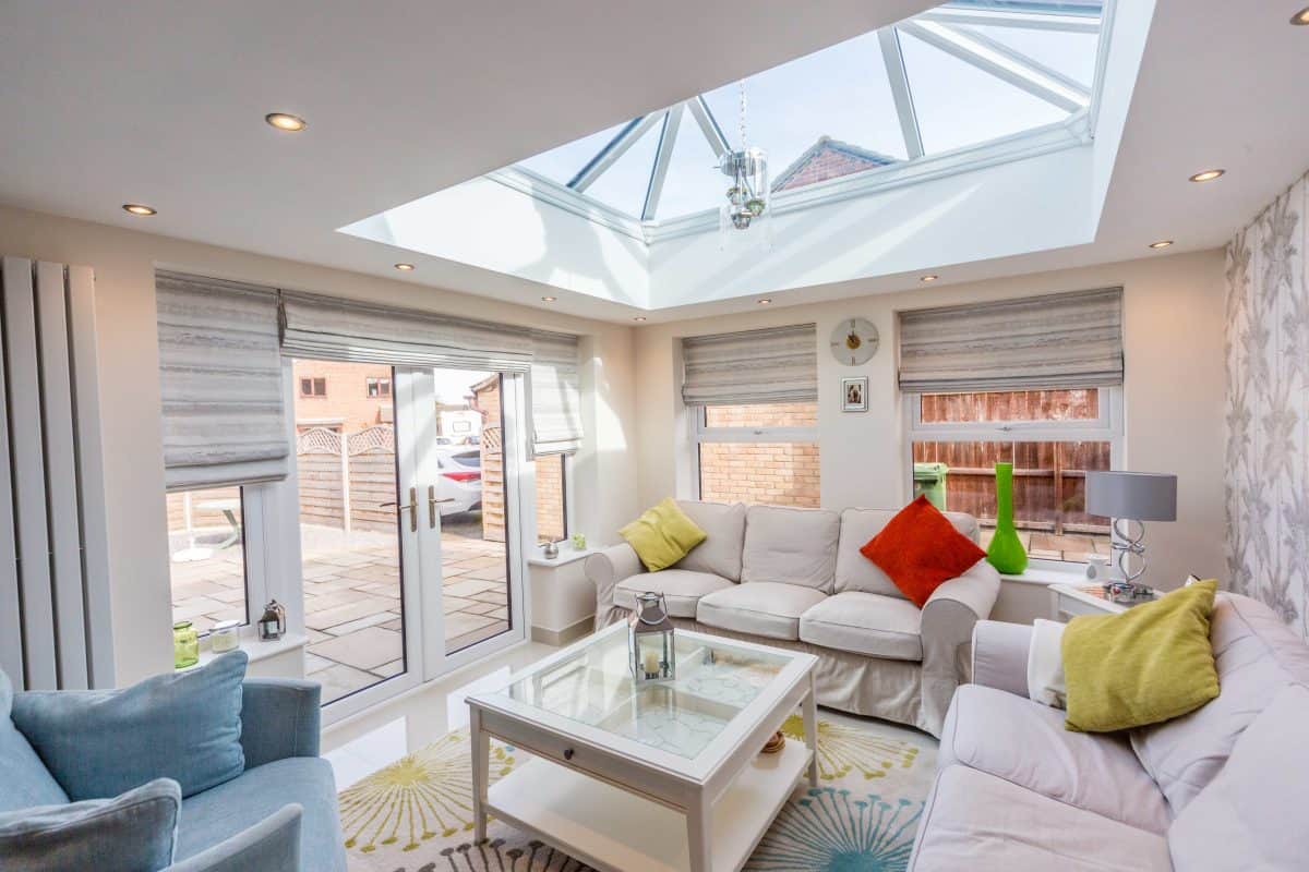 Bright living room with large skylight, neutral sofas, and colourful cushions in Bournemouth.