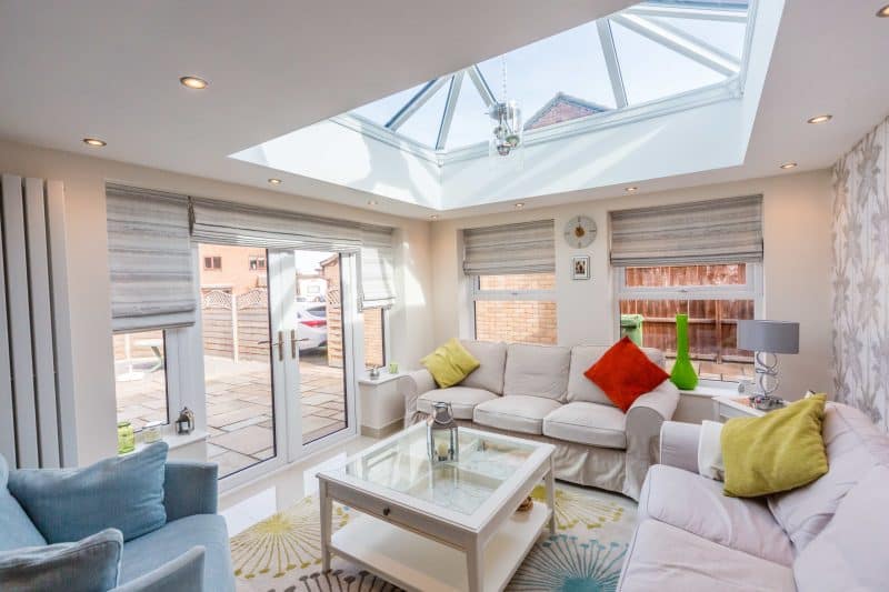 Bright living room with large skylight, neutral sofas, and colourful cushions in Bournemouth.