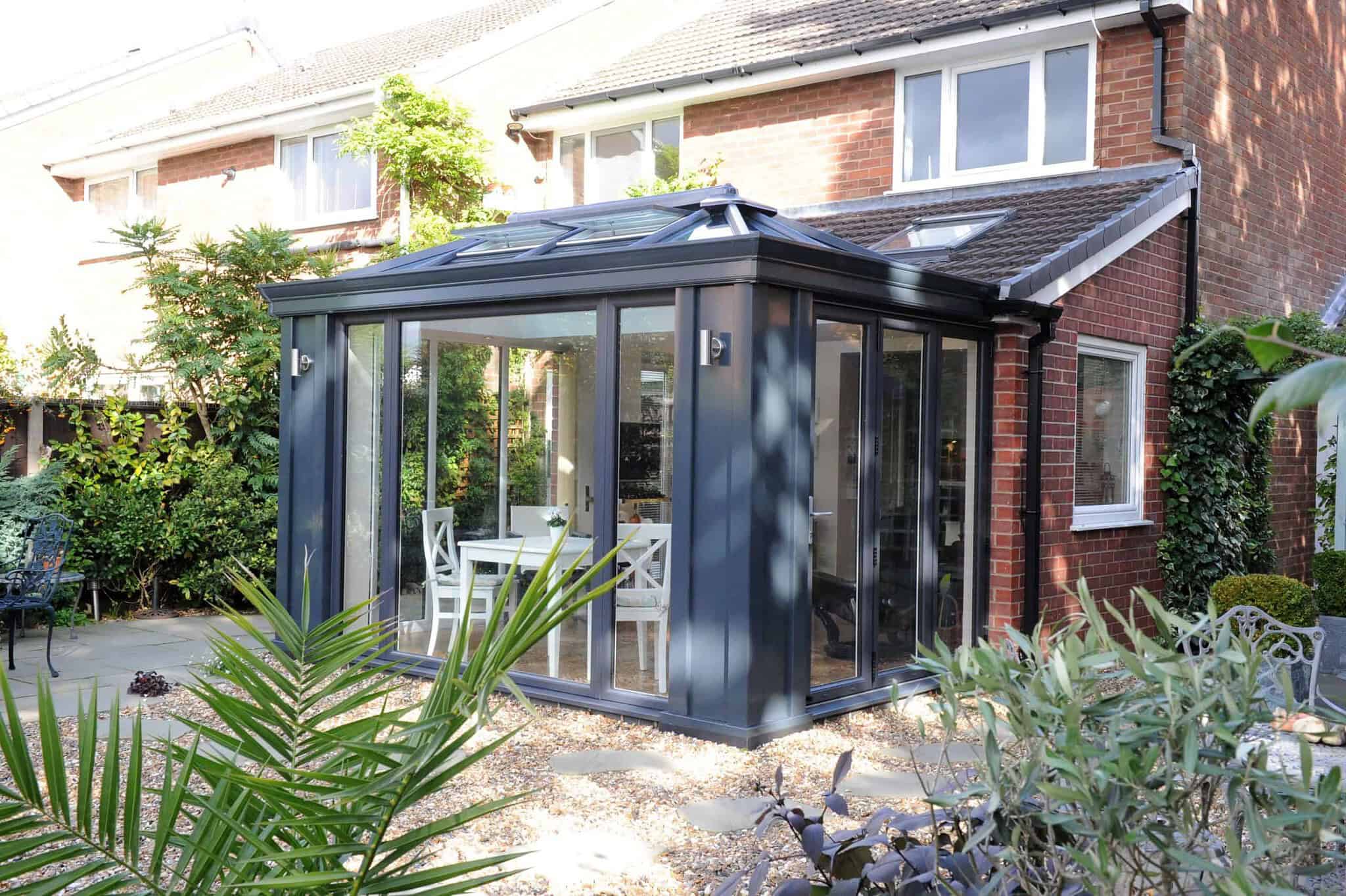Modern glass conservatory in Poole & Bournemouth with black frame and garden view.